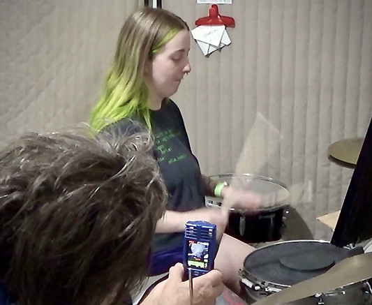 Steve Lord, Saint Louis Drum Lessons instructor records female student to check sound and technique on drum set.