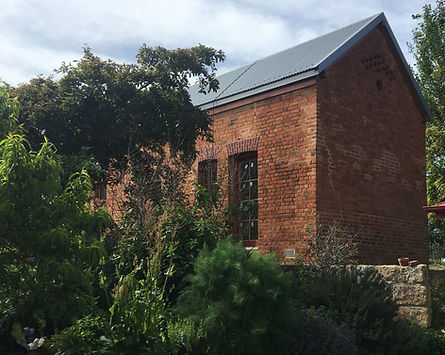 Rear view of The Quarters heritage brick building showing original stonework and character