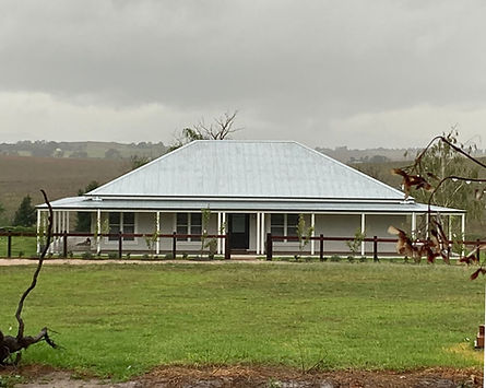 Sadlier House cottage exterior set in open paddock with overcast sky