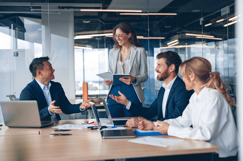 A photo of four people around a desk having a meeting