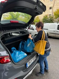 Woman putting bags in car, Στήριξη Stirixi Ομάδα Εθελοντισμού, street background