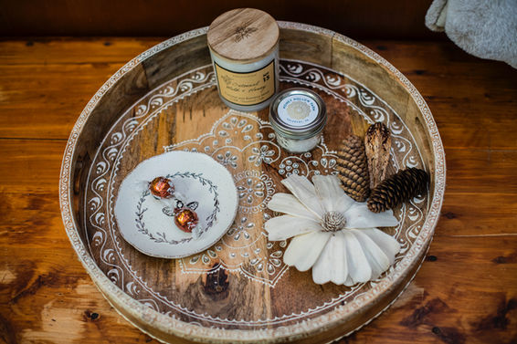 Ornate round tray with a white flower and jars