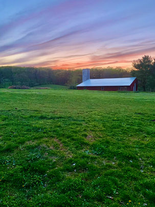 Sunset behind a red barn