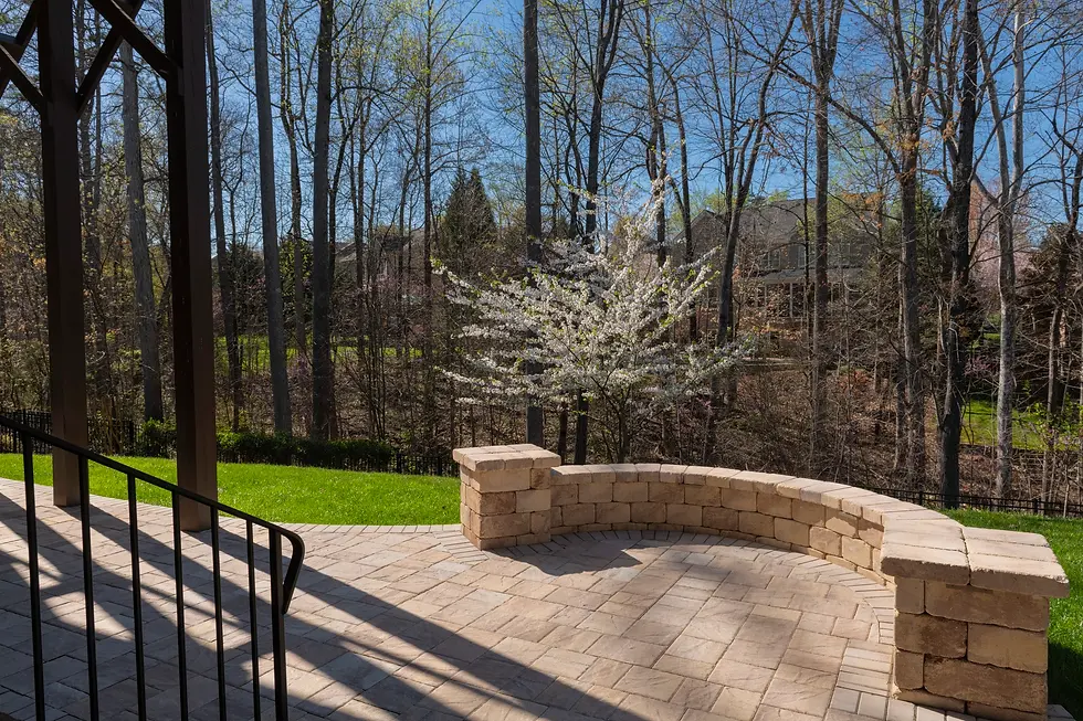 Backyard with patio pavers and stone wall in spring season