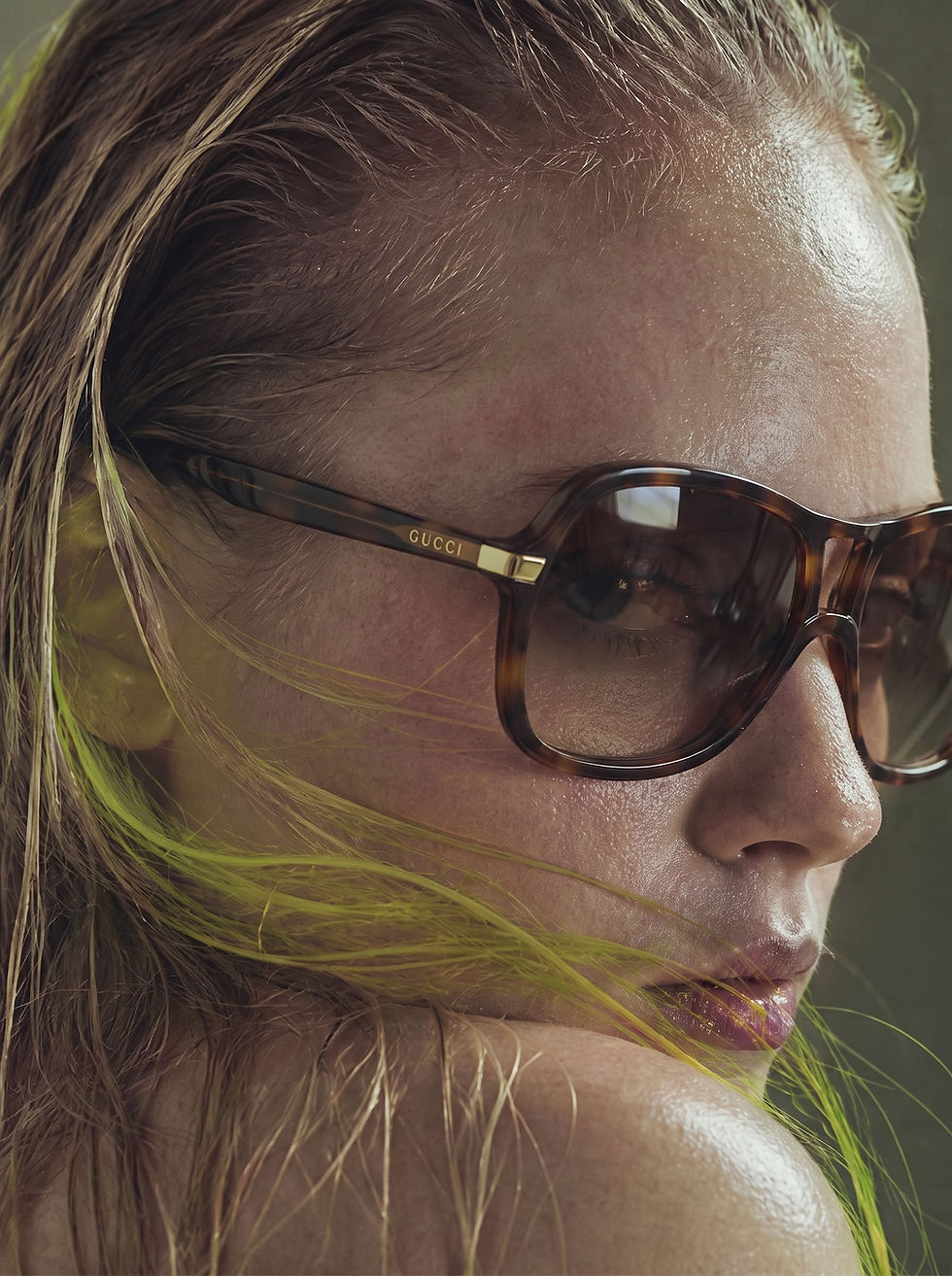 Woman with wet hair wearing tortoiseshell sunglasses.