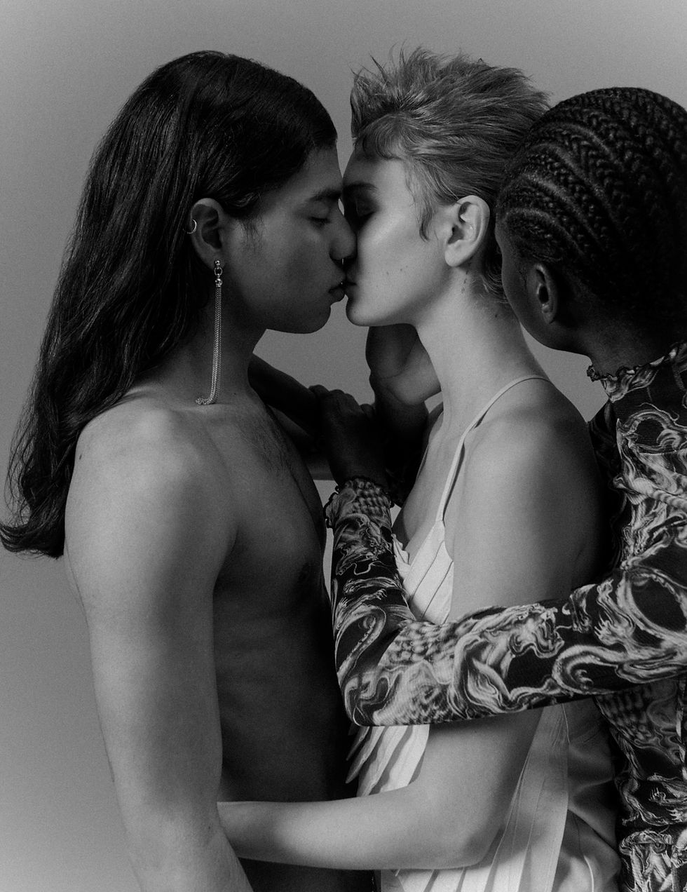 Three models in a striking black-and-white composition, featuring a moment of intimacy and
