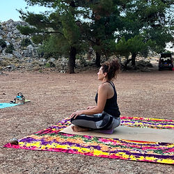 Forest Yoga: Woman meditating outdoors among trees.