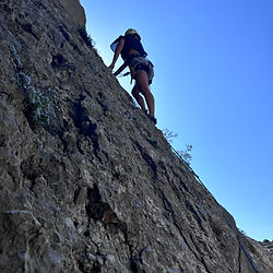 Person rock climbing a steep rock face