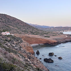 Small white building on a rocky coastal cliff overlooking the sea