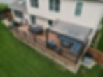 Raised Trex composite decking with railings and free-standing pergola with open slats.