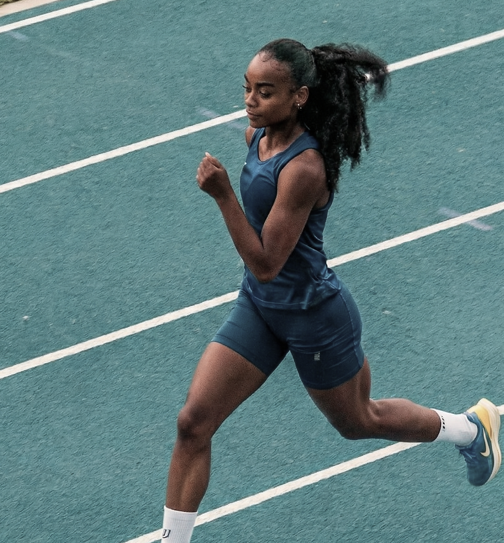 Female athlete sprinting on a blue running track.