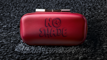 Sunglass case with the No Shade logo spray-painted on, placed on a gritty city street for an edgy, urban feel.