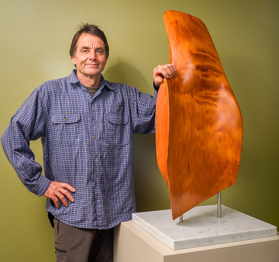 Tony Howse with sculpture made from salvaged Coromandel Kauri Wood at Kauri Cliff Art Gallery in Whangamata, New Zealand