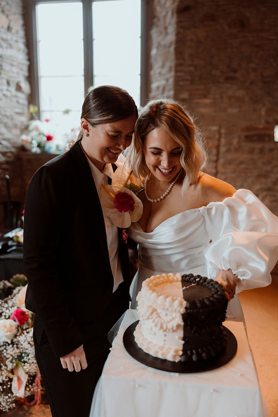 Wedding LGBTQI+ couple cutting a black and white wedding cake