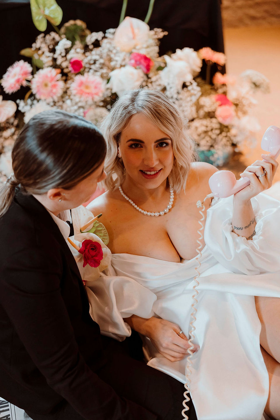 Two brides with a pink audio guest book