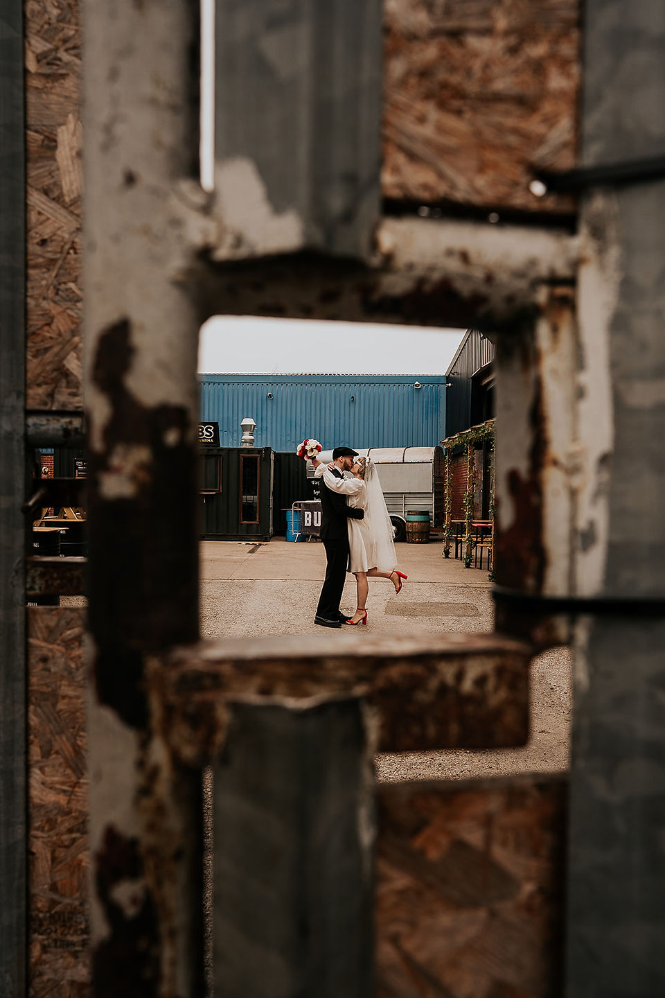 Couple posing outside in an industrial wedding venue