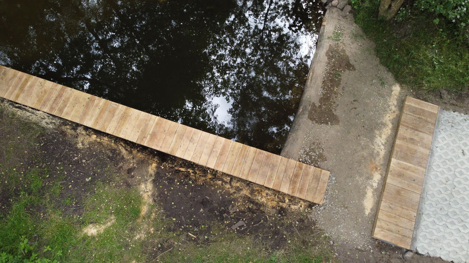 Steg mit Eichenbelag und Ufer aus Holz mit Pflasterfläche aus Rasengittersteinen
