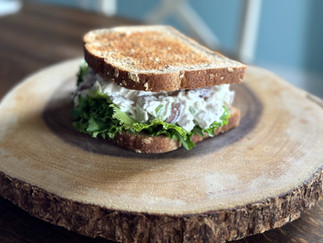 Chicken salad sandwich on a wooden board