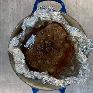 Cooked pot roast revealed from being cooked in foil inside a dutch oven