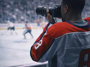 Atleta profissional fotografando jogo esportivo com câmera profissional em arena