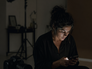 fotógrafa no estúdio checando a rede social