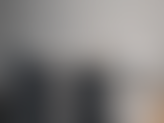 Duas pilhas de fotografias impressas e folhas de contato se fundindo em uma única pilha maior sobre mesa neutra, metáfora visual de consolidação no mercado de bancos de imagem