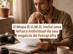 Fotógrafo analisando documentos em mesa de trabalho com câmera analógica e luz natural