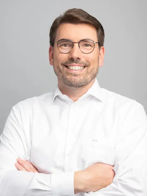 Mitarbeiter einer Firma aus Hannover im Portrait vor grauem Hintergrund.