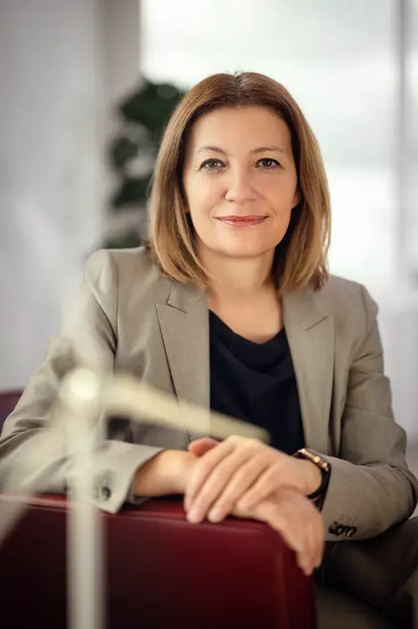 Die Vorstandsvorsitzende von Enercity in Portrait in ihrem Büro. Im Vorderund ist unscharf ein Windradmodell zu erkennen.