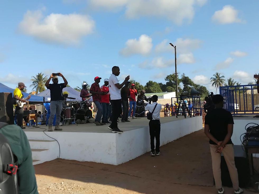 A young resident films the stage performance at the Muxara inauguration, shot from behind