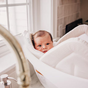 In-home newborn photography session capturing real family moments with baby at home