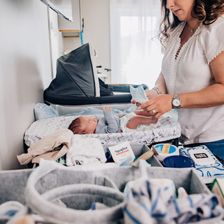Parent changing their newborn on a changing table at home during an in-home newborn session