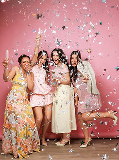 Fun Boston group photoshoot of four women celebrating with confetti against a pink backdrop, capturing a playful and joyful moment