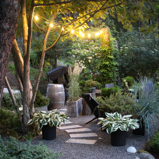 a granite paved walkway by a fireplace with outdoor lighting