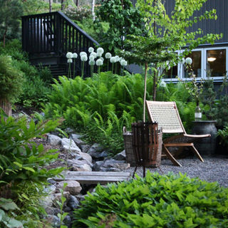 garden architecture with a stream with a bridge and ferns