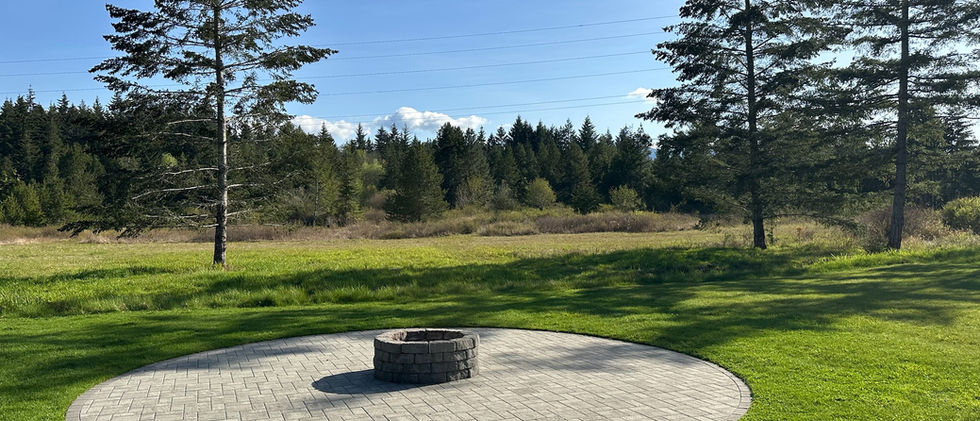 completed paving stone patio and firepit with surrounding grass 