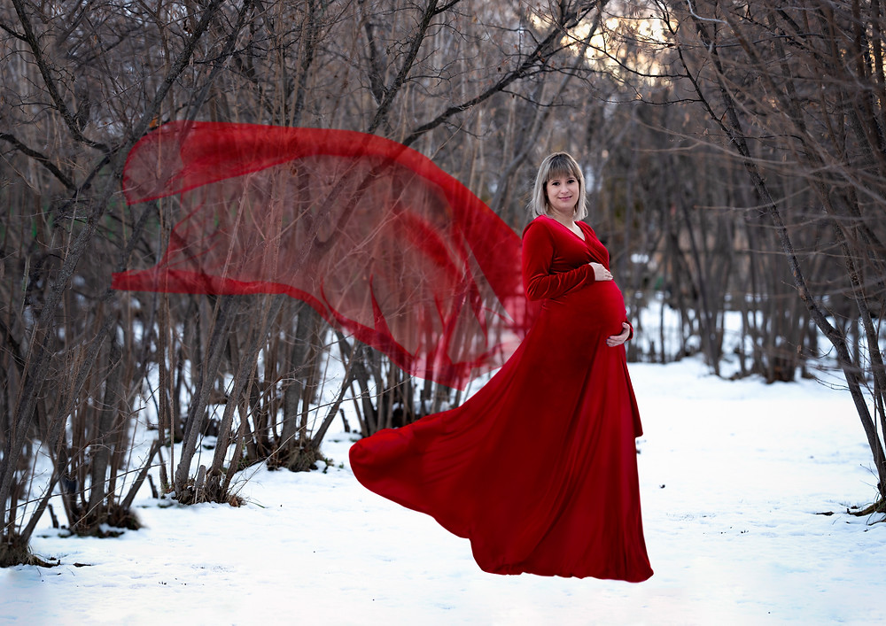 Red dress maternity in snowy forest