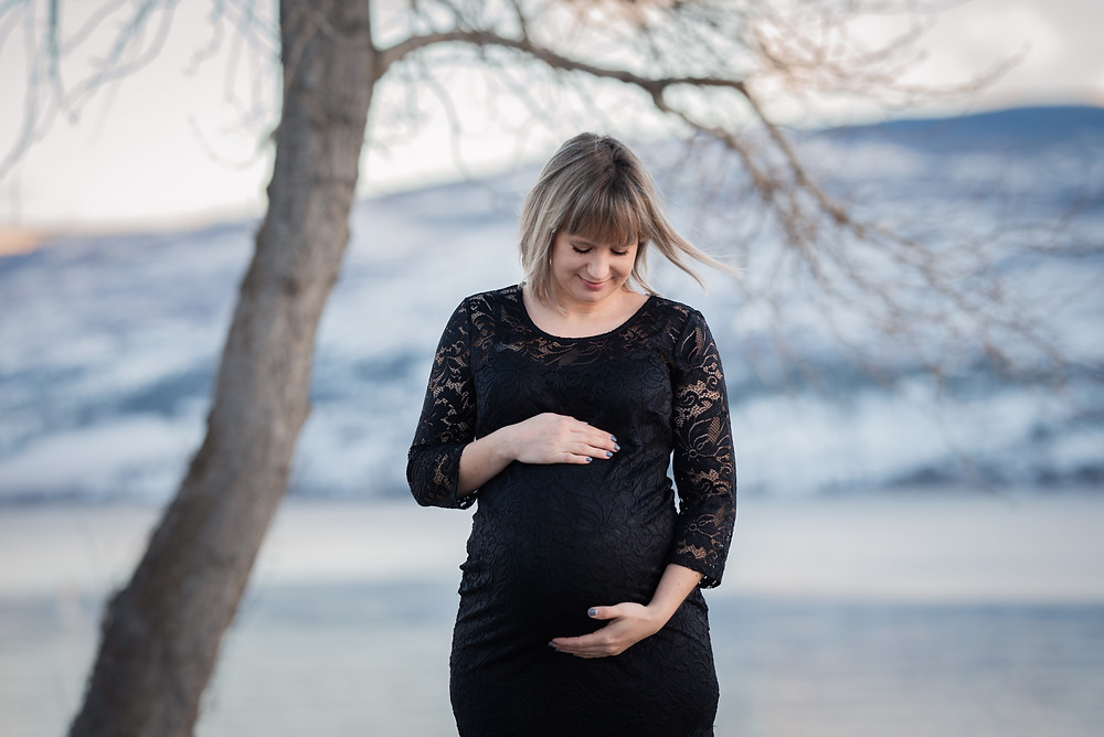 black dress maternity by lake and mountains