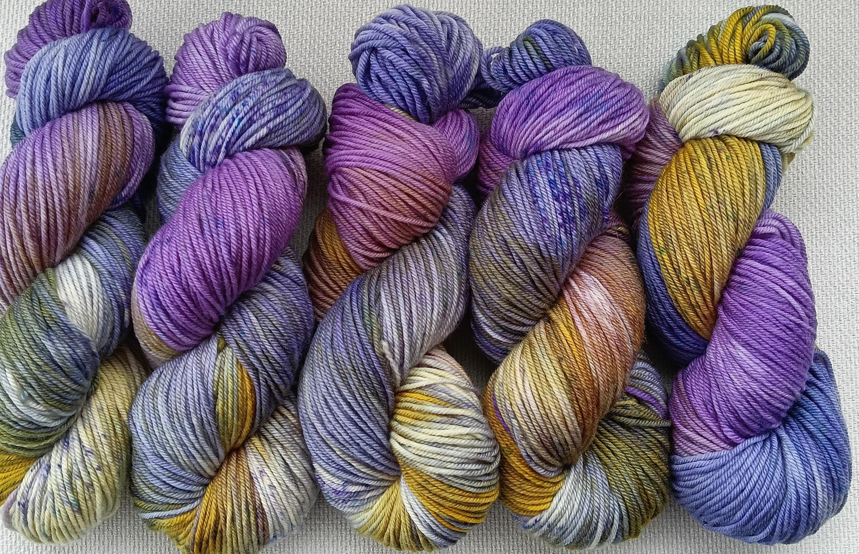 Hank of 8ply yarn hand dyed in blues, purples, yellows, & greens