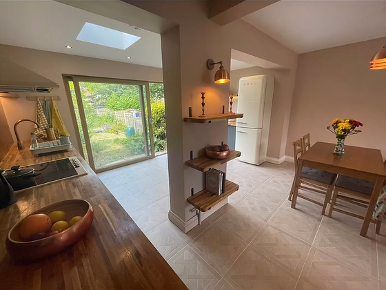 Modern open-plan kitchen renovation in the West Midlands featuring charcoal cabinets and wooden worktops.
