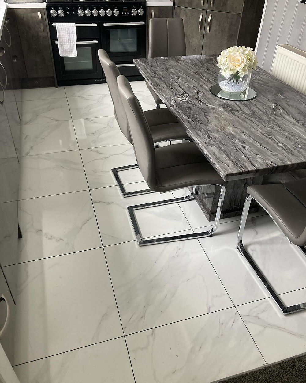 Modern fitted kitchen with tiled floor and dining table