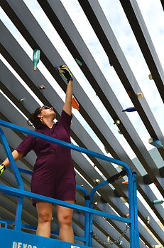 Kara Artman placing magnetized colorful ceramic bottles on a metal pavilion.