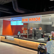 3d letter glowing signage that reads mini kabob in a food court