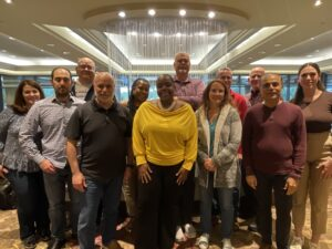 Team of colleagues stand together in front of an elegant indoor waterfall