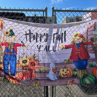 An autumn-themed banner displaying a scarecrow and a pumpkin, saying "Happy Fall Y'all" capturing the essence of fall festivities.