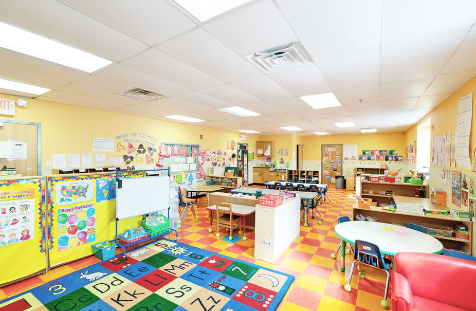 A cozy classroom featuring wooden tables surrounded by chairs for students