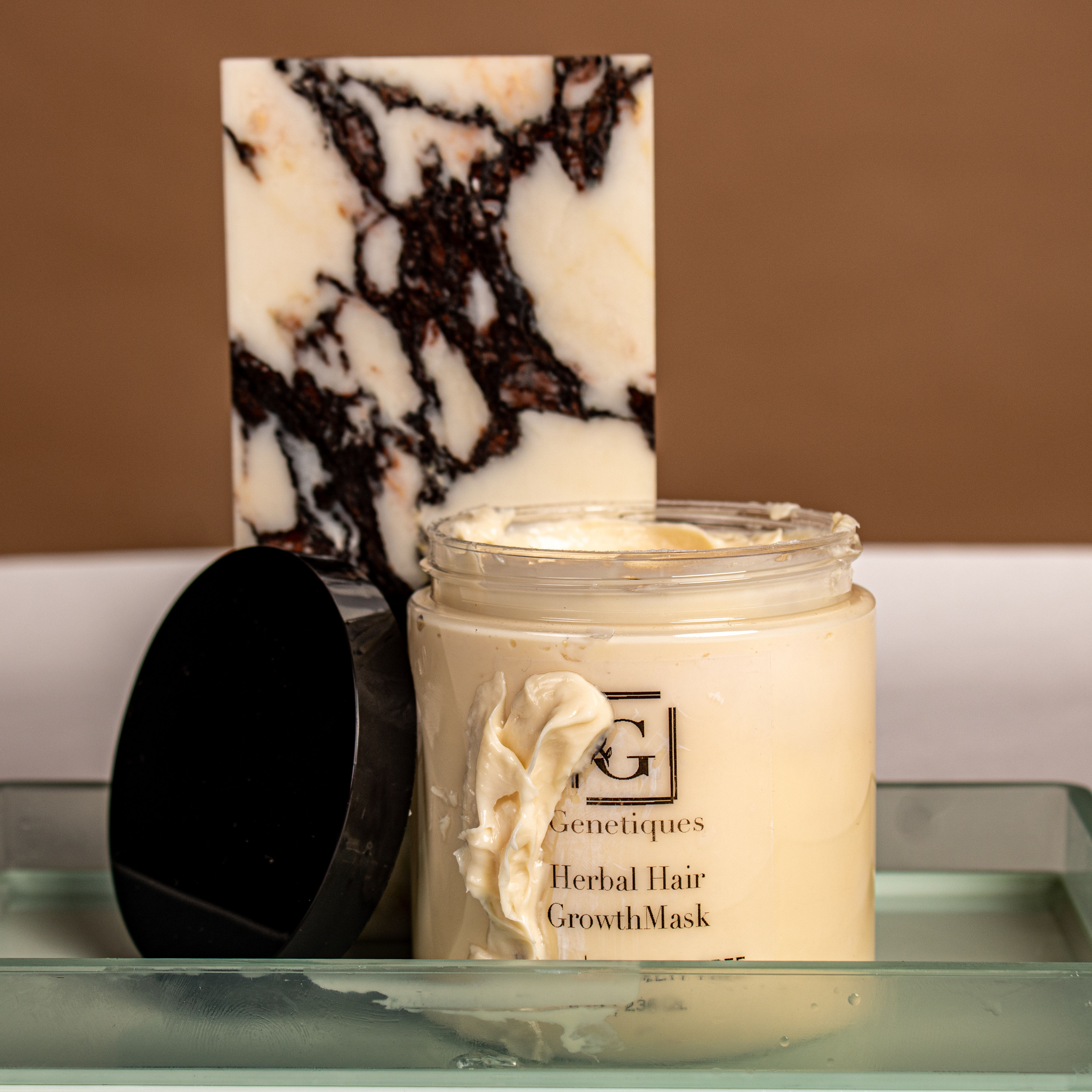 Jar with Herbal Hair Growth Mask and marble slab on a tray. Genetiques Hair and Beauty.