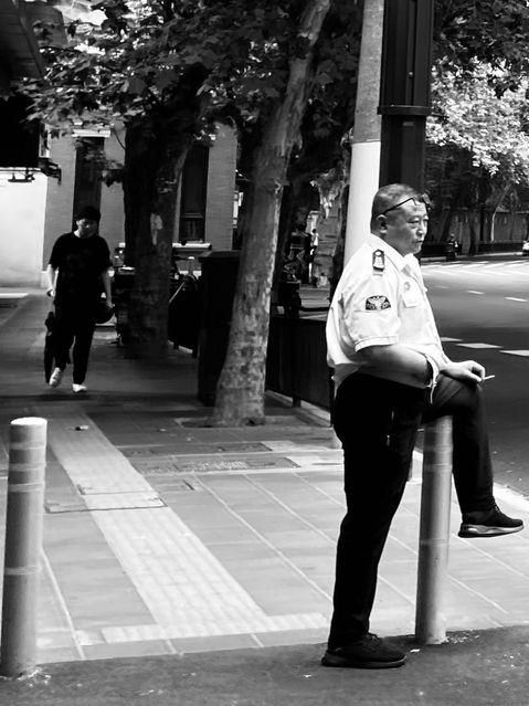 Security guard taking a break and smoking a cigarette in Shanghai, China