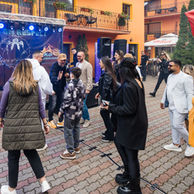 Public la concert in curtea interioara a hotelului cu scena si artisti pe fundal