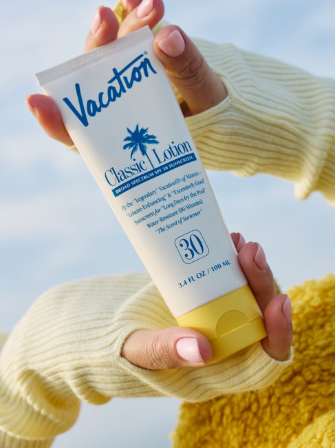 woman holding sunscreen in a lifestyle setting